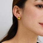 gold plated rounded dome stud earring worn on the ear