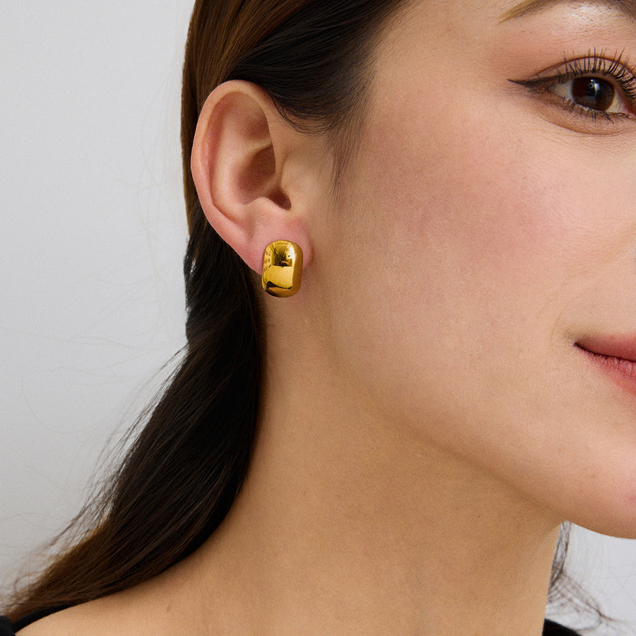 gold plated rounded dome stud earring worn on the ear
