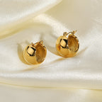 rounded gold plated stainless steel huggies styled on satin