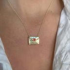 closed envelope pendant necklace with a red heart-shaped stone