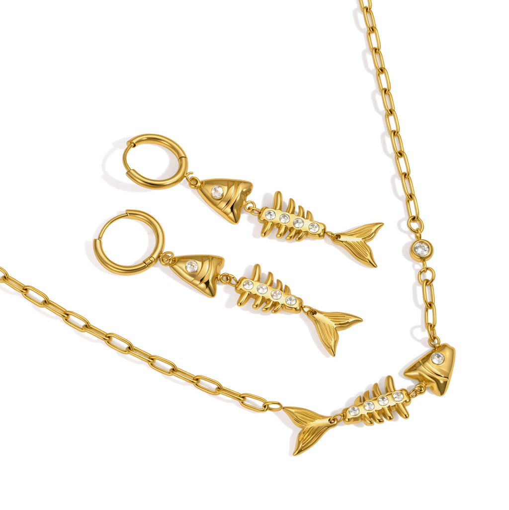 Gold tone necklace and fishbone hoop earrings on white background