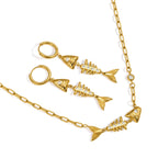 Gold tone necklace and fishbone hoop earrings on white background
