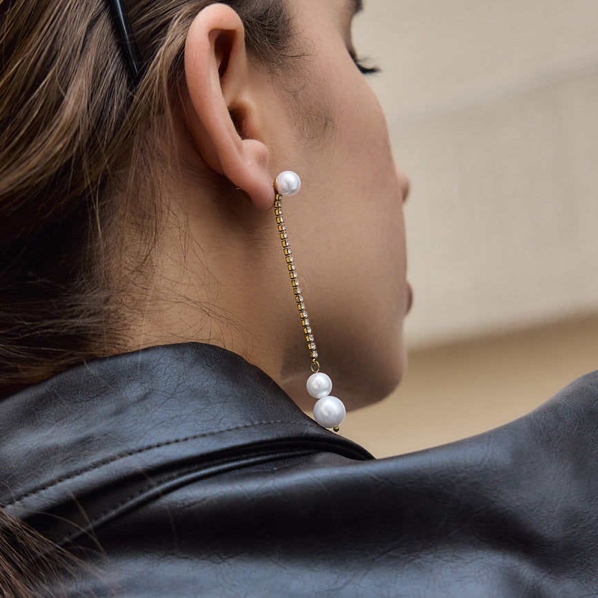 Side view of gold tone pearl drop earring on an ear
