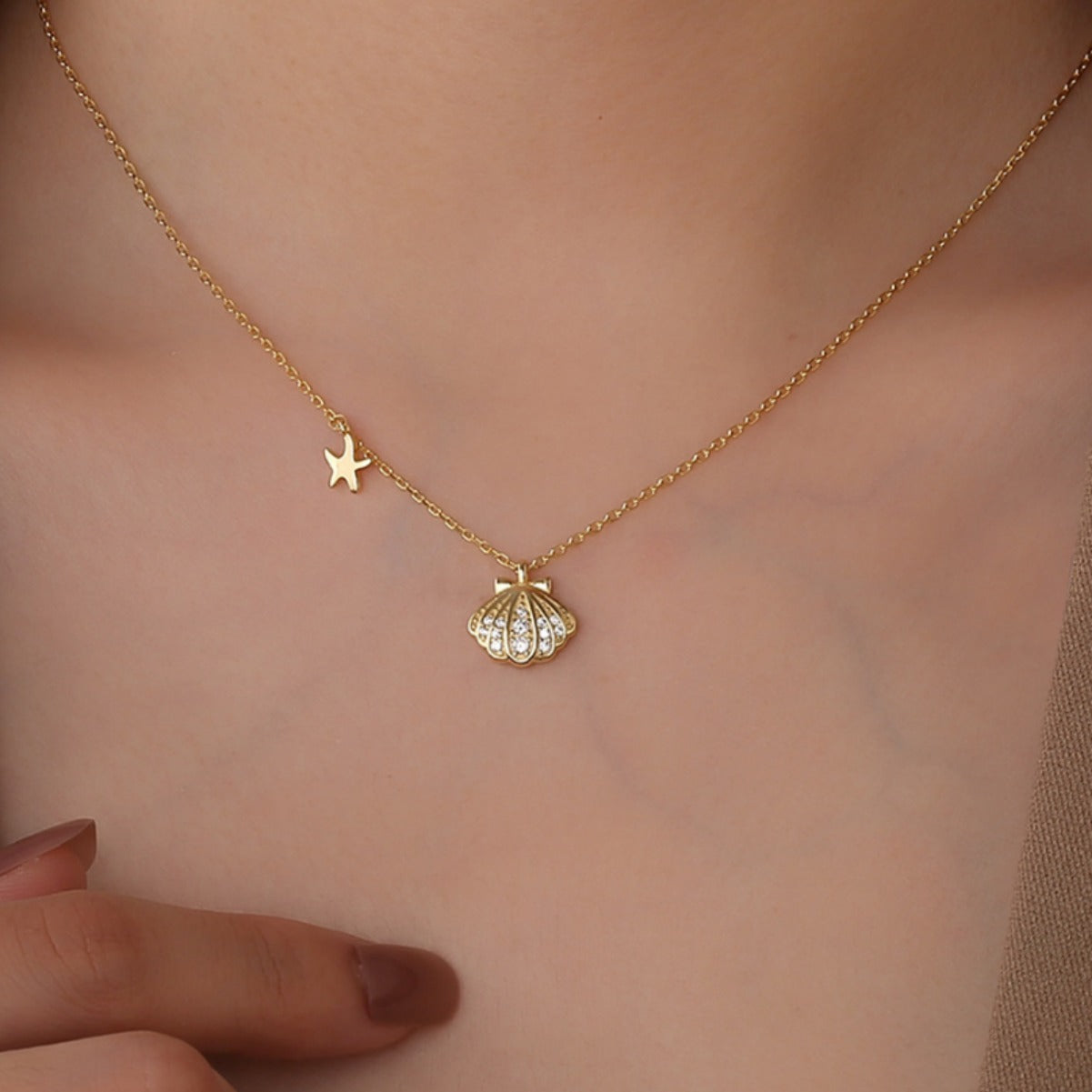 seashell and starfish necklace worn at the collarbone