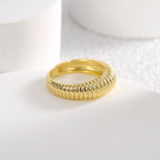 angled gold plated ribbed dome ring on a pale display