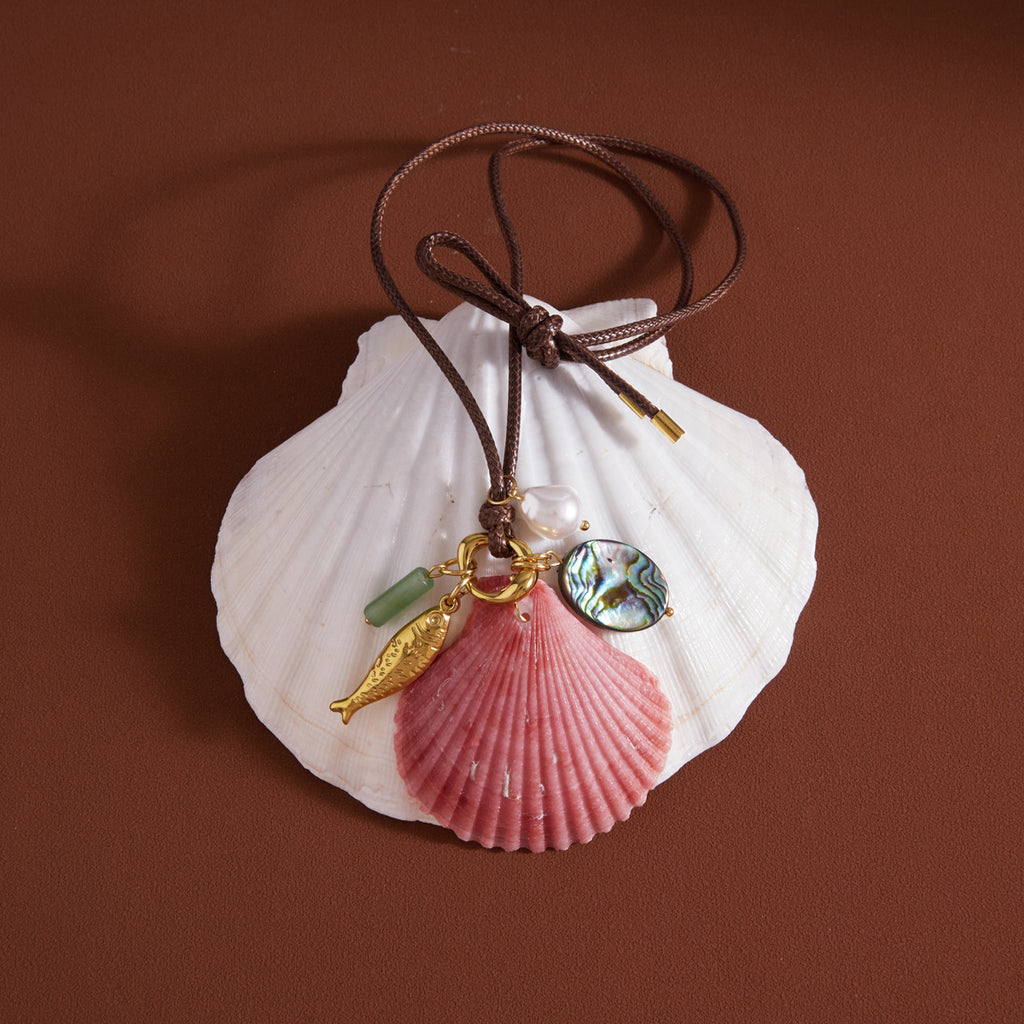 Pink scallop shell charm necklace tied in a bow