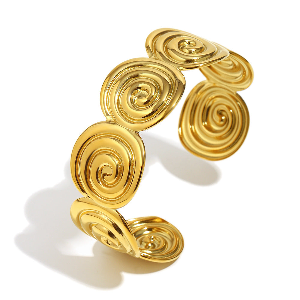Gold plated spiral disc stainless steel cuff on white