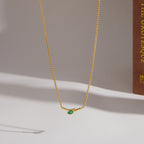 Single curved bar necklace with green center stone