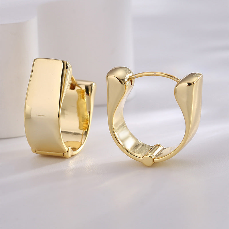 front and side views of gold plated brass huggie earrings