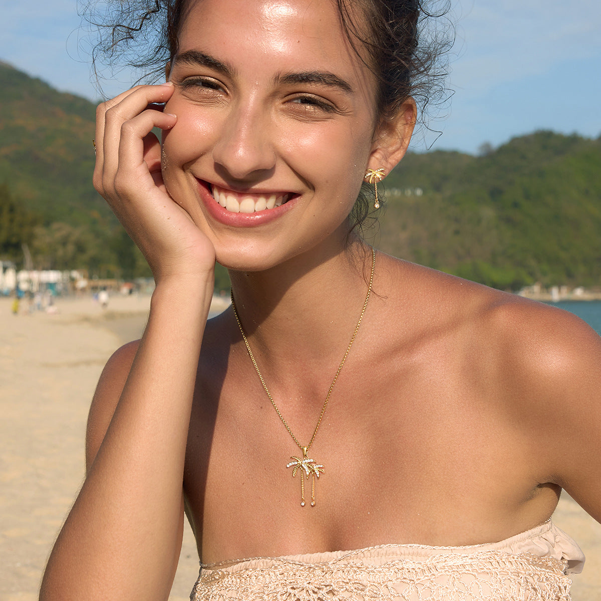 Palm pendant necklace styled with matching earrings