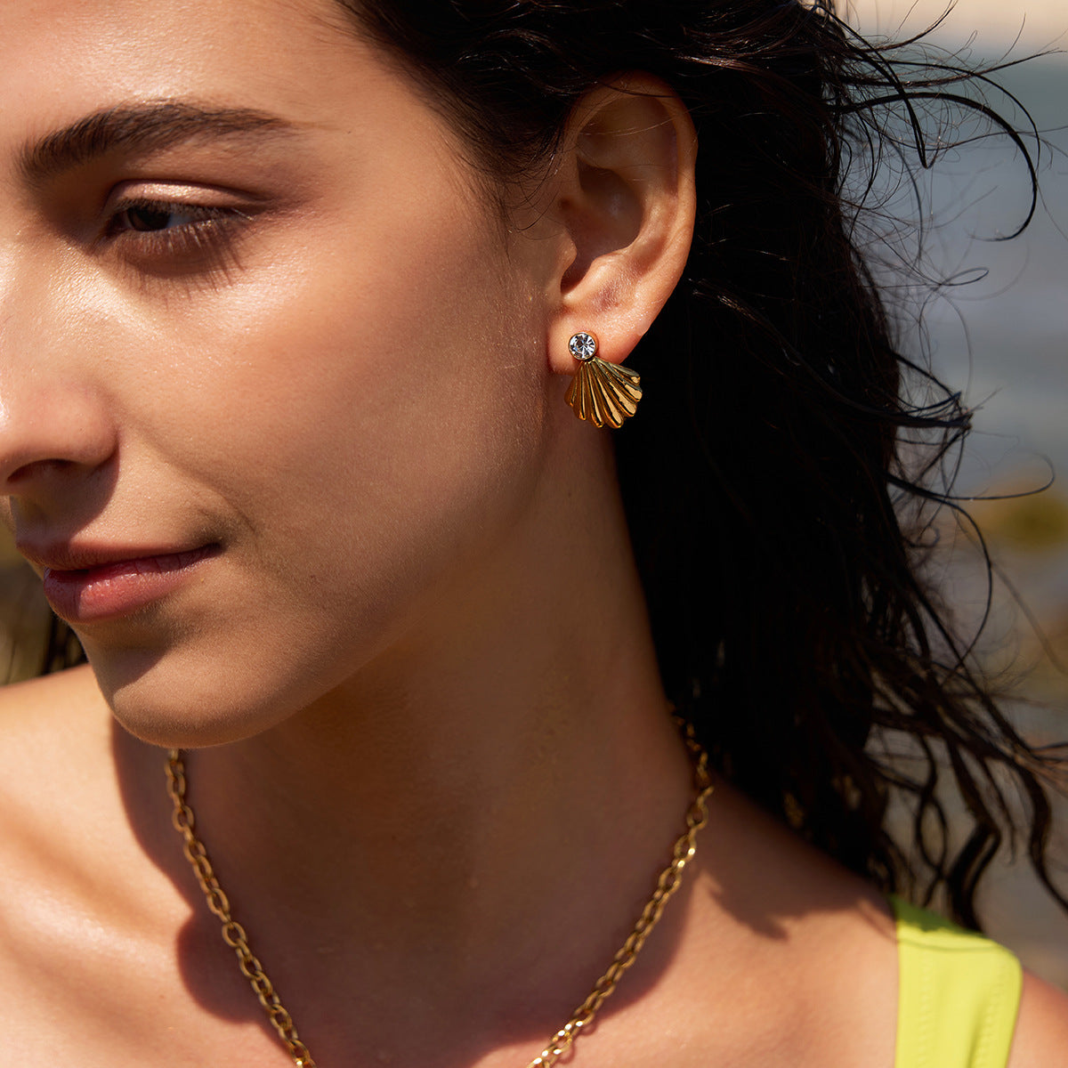 Close-up of gold finish shell stud worn on ear