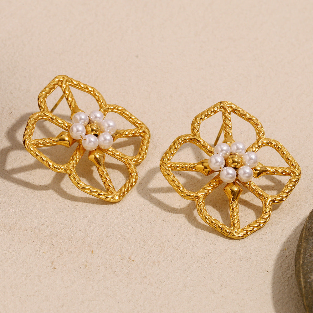 gold plated four-petal flower studs displayed on stone