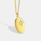 gold plated brass oval pendant with engraved starburst and clear center stone