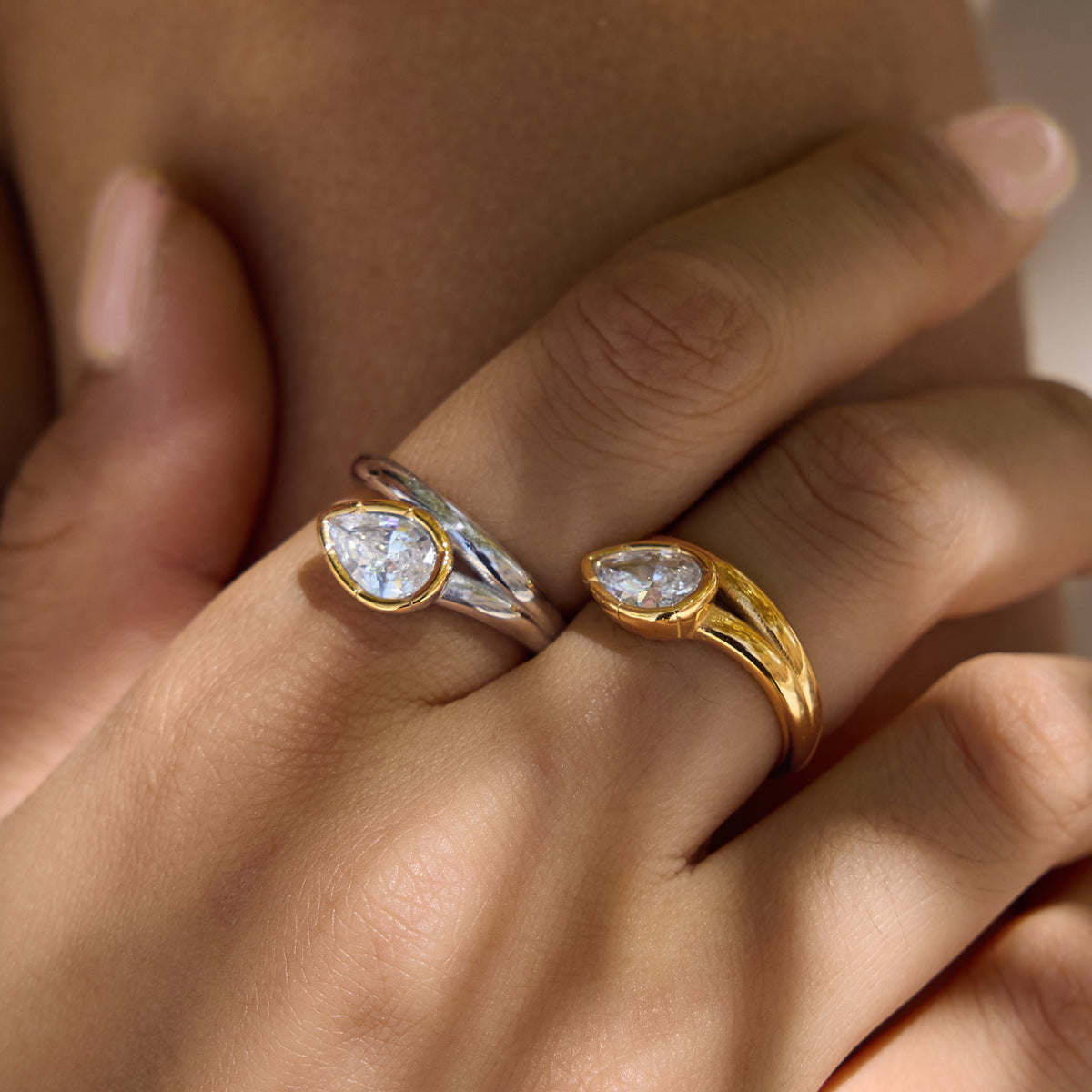 Angled pear stone rings worn on fingers