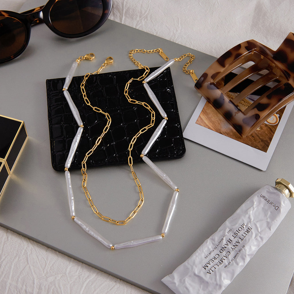 Both necklaces laid out beside accessories