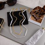 Both necklaces laid out beside accessories