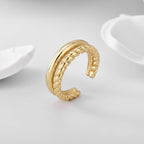 upright gold plated braided open ring on a pale display