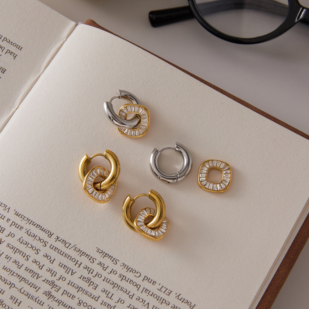 Gold tone and mixed-tone rhinestone disc hoops on a book