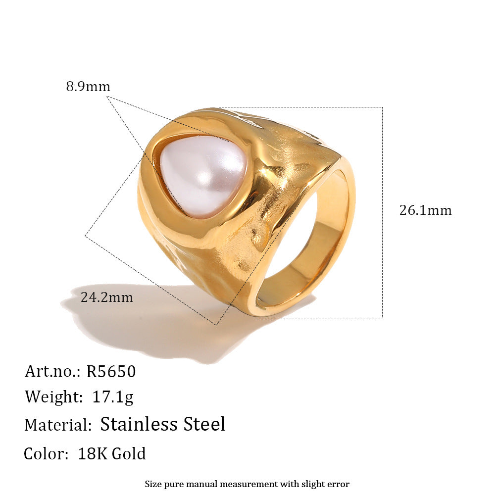 Gold tone ring showing teardrop center and broad shoulder measurements