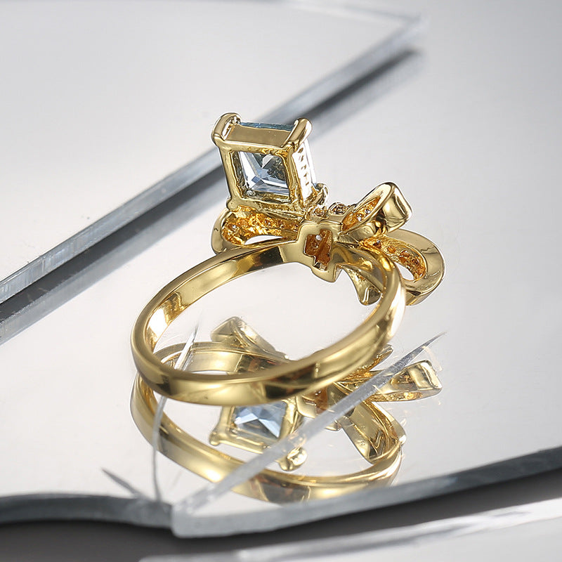 rear angled view of raised blue-stone bow-knot ring