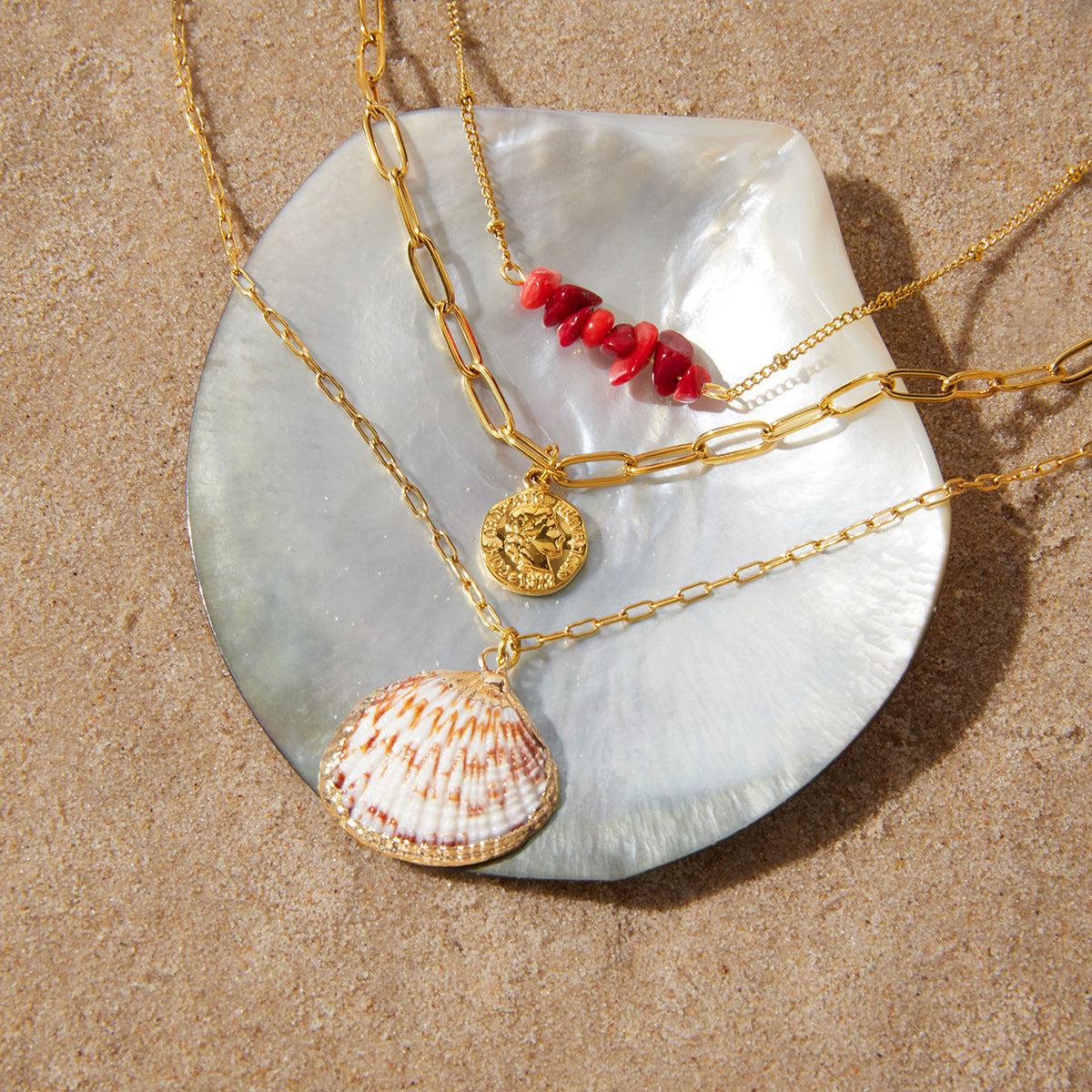 Red bead coin and shell necklace displayed on shell