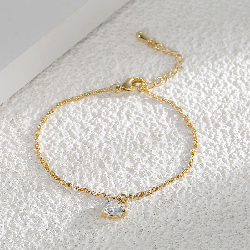 clear heart-shaped stone bracelet arranged on textured white fabric