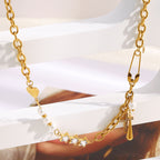 asymmetrical gold plated charm necklace on an iridescent display