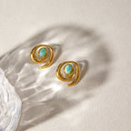 Gold-tone spiral stud earrings with green oval centers