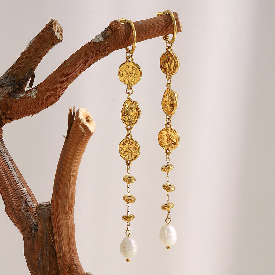 gold plated textured medallion pearl drop earrings hanging from a branch