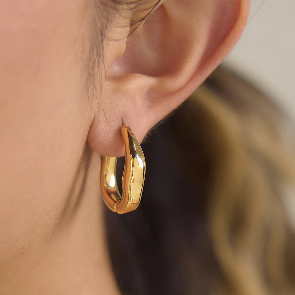 Close-up of the wavy hoop outline on an earlobe