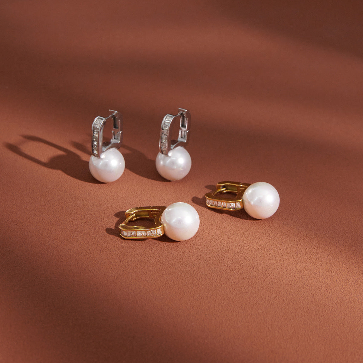 paired resin pearl huggie earrings in gold and silver finishes