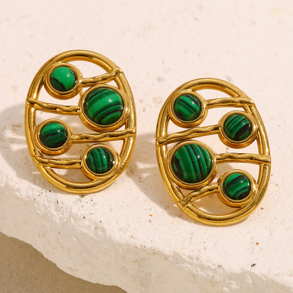openwork oval malachite stud earrings styled on cream stone