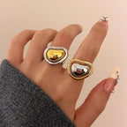 Two reverse-color heart rings shown together on a hand