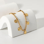 Disc charm anklet draped over a white curved display