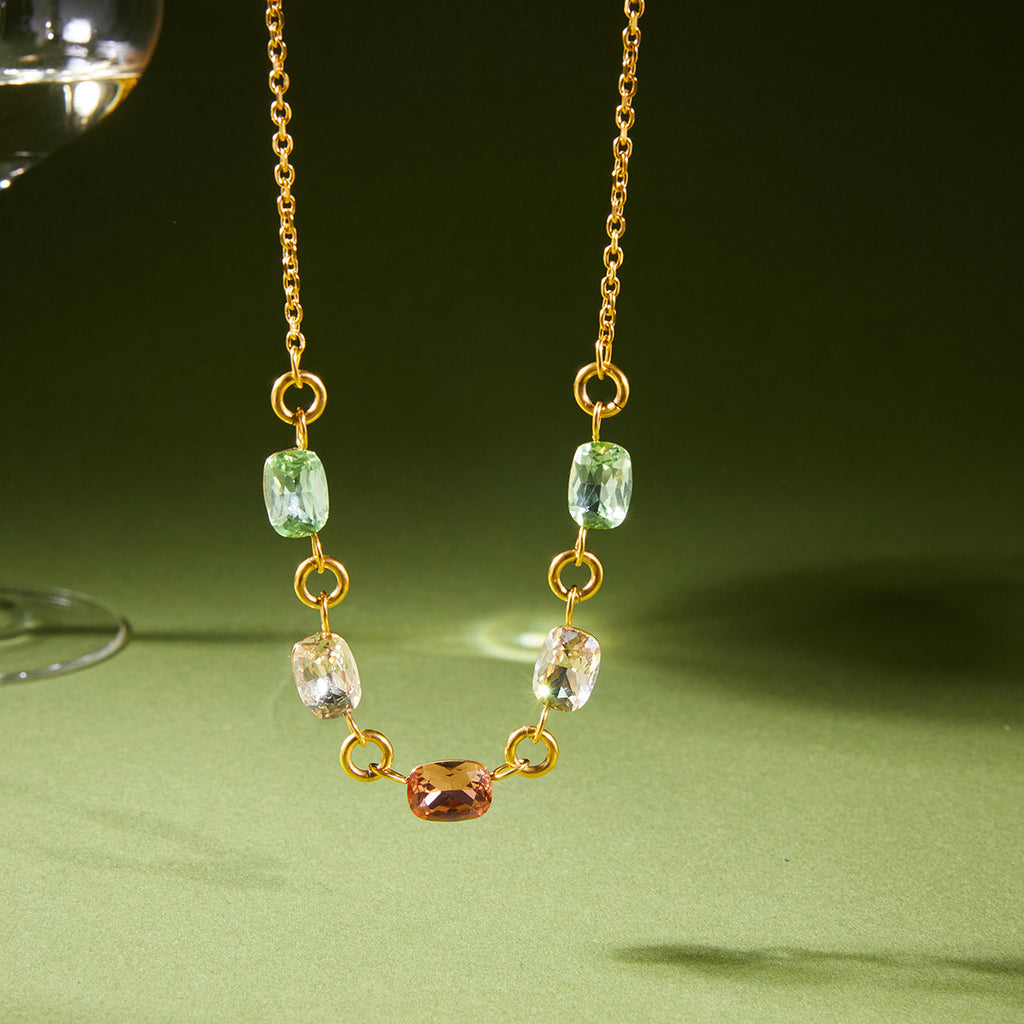 Pastel stone stainless steel necklace displayed against a green background