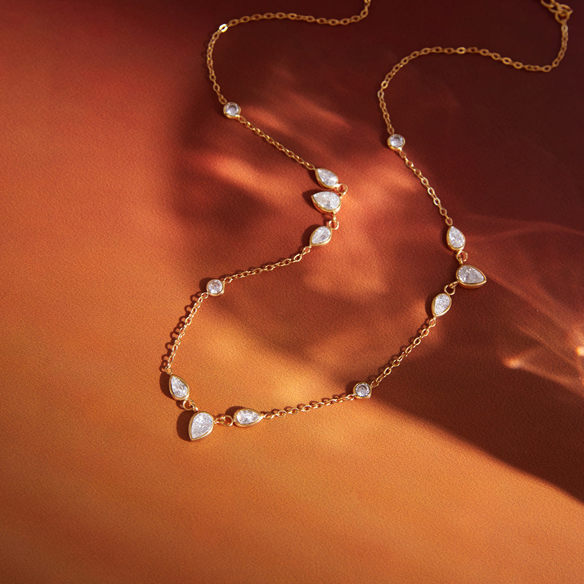 round and pear-cut clear-stone necklace on warm fabric
