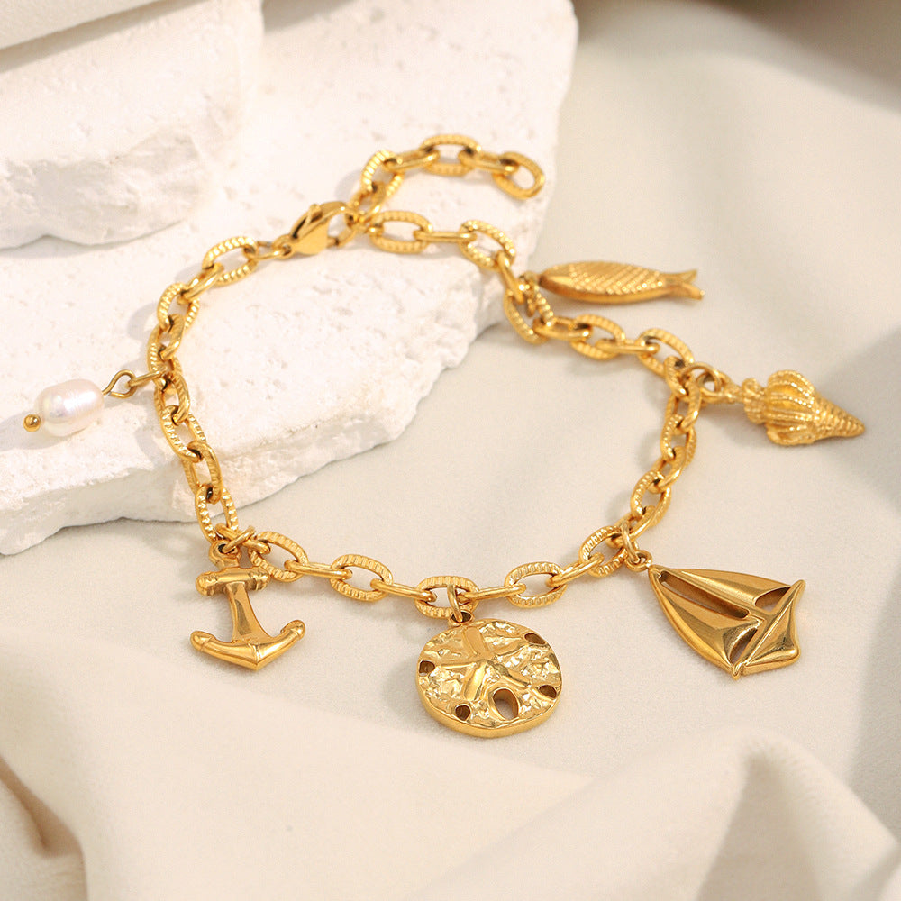 Gold Plated 316L Stainless Steel Coastal Charm Bracelet — charms and clasp on pale stone