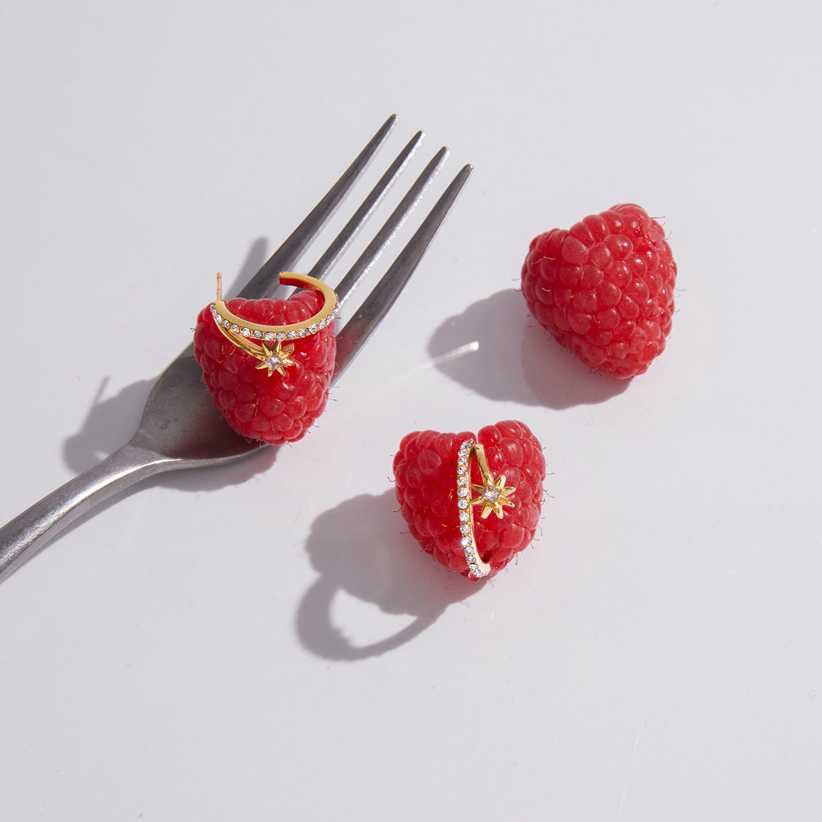 Starburst hoops arranged on raspberries beside a fork