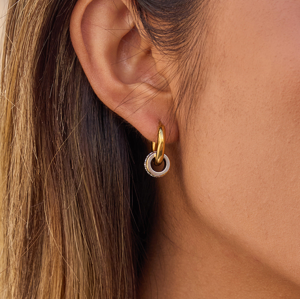 Model wearing two-tone interlocking loop hoop earrings