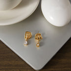 Front and reverse of multi-loop drop earrings on a board