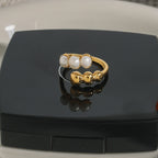 Gold plated white bead and ball open ring in a styled display