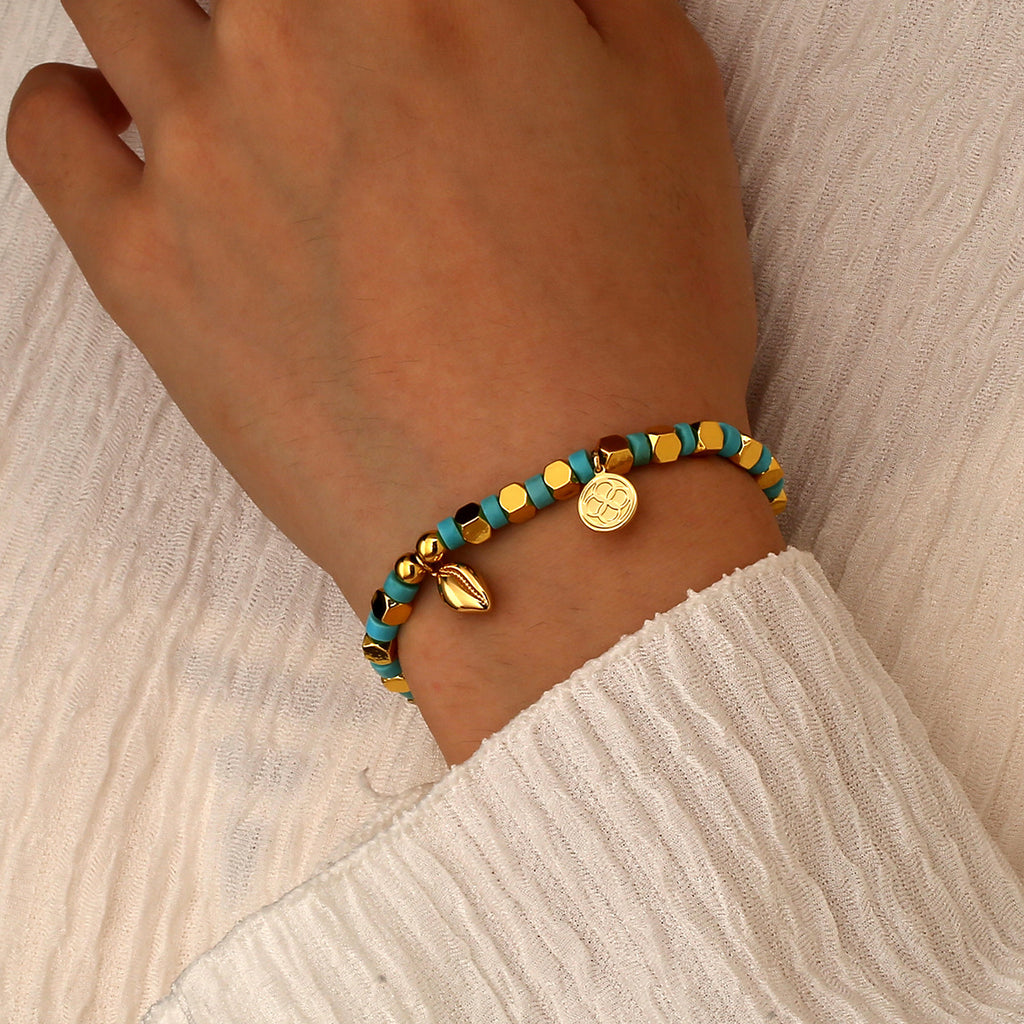 model wearing the turquoise-color cowrie bead bracelet