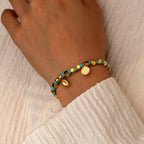 model wearing the turquoise-color cowrie bead bracelet