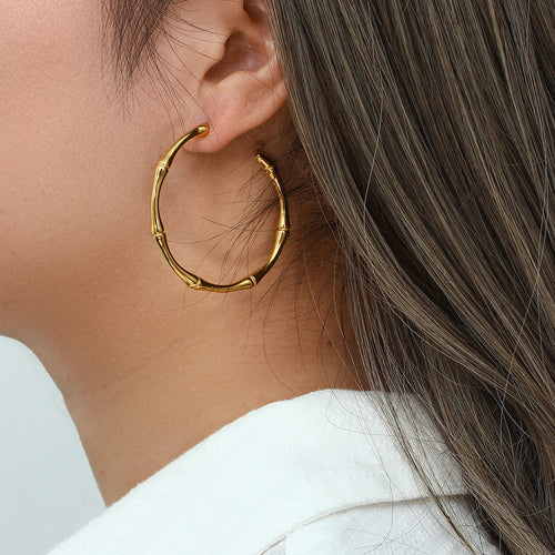 Large bamboo-section hoop earring worn on the ear