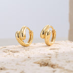 gold plated brass triple-lobe huggie hoop earrings on stone