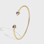 isolated gold plated open cuff with purple triangle stones