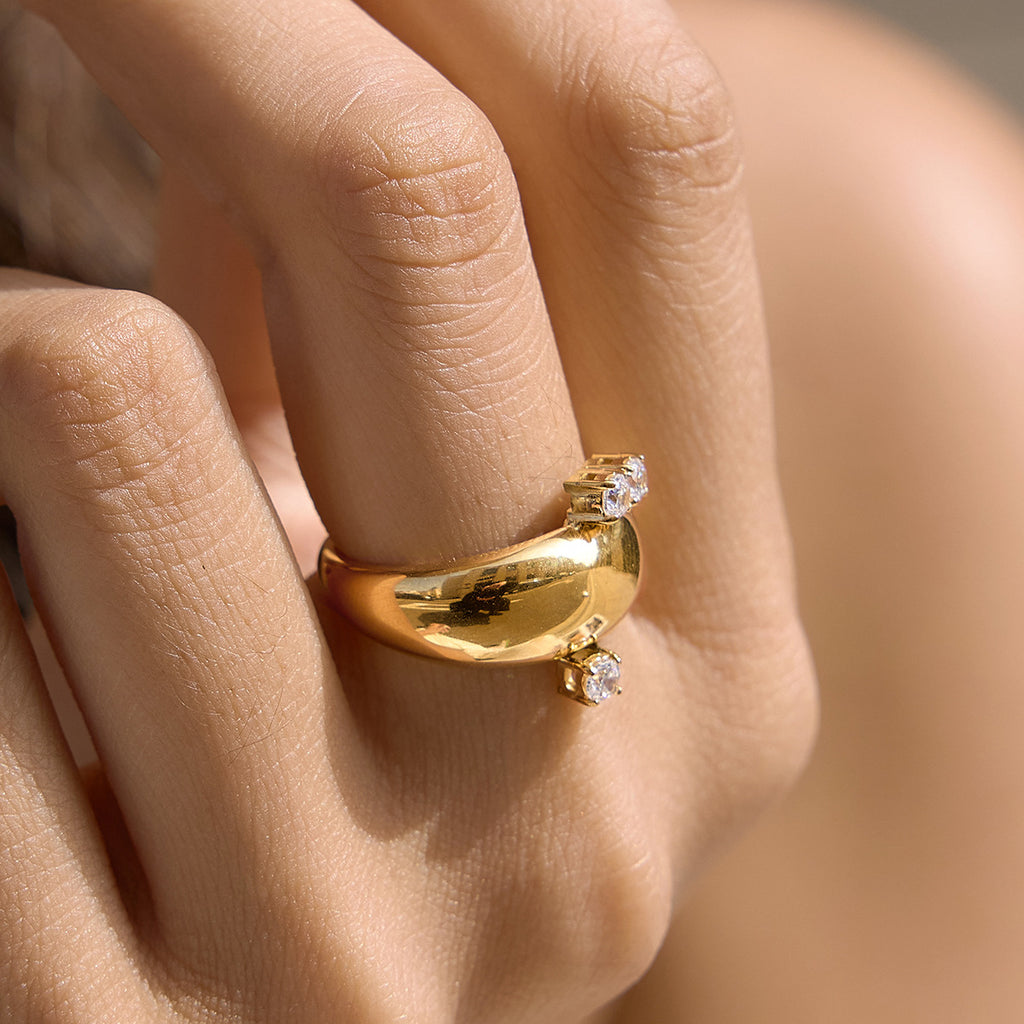 Close-up of polished gold tone dome ring on a finger