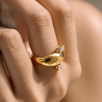 Close-up of polished gold tone dome ring on a finger