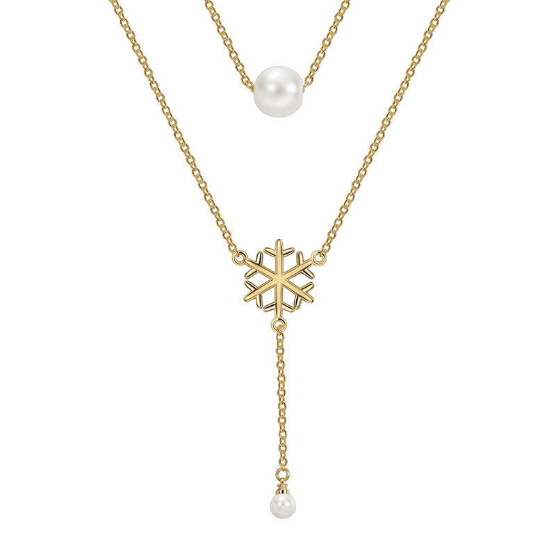 isolated gold plated snowflake drop necklace with two shell pearl beads
