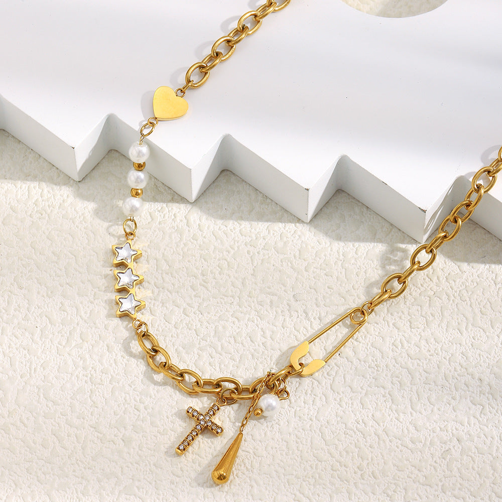 clear-accent cross and teardrop charms beside a safety-pin detail